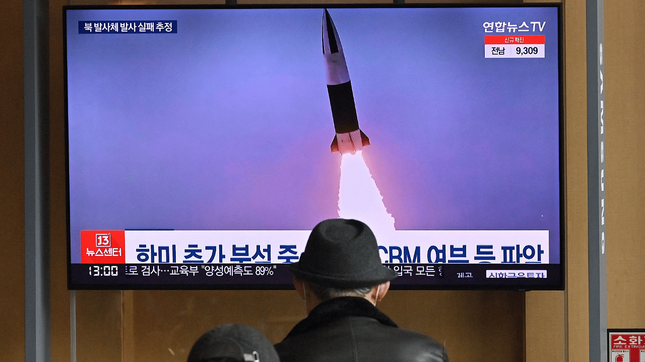 People watch a television screen showing a news broadcast with file footage of a North Korean missile test, at a railway station in Seoul on March 16. Credit: AFP Photo
