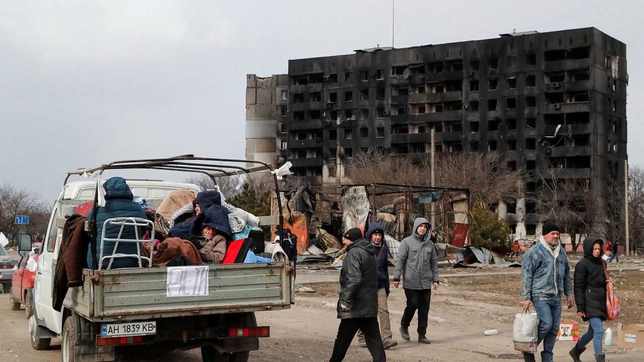 Evacuees fleeing Ukraine-Russia conflict sit in the body of a cargo vehicle while waiting in a line to leave the besieged southern port city of Mariupol, Ukraine. Credit: Reuters Photo