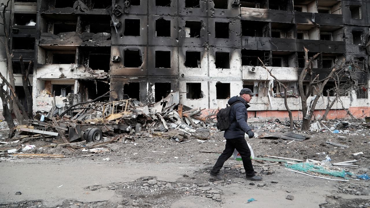 A man walks near a block of flats, which was destroyed during Ukraine-Russia conflict in the besieged southern port city of Mariupol. Credit: Reuters Photo