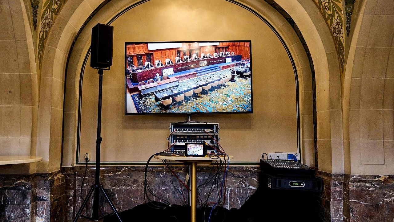 This photgraph taken on March 16, 2022 shows empty seats at the place of the Russian delegation on screen during the ruling in the case about war in Ukraine. Credit: AFP File Photo