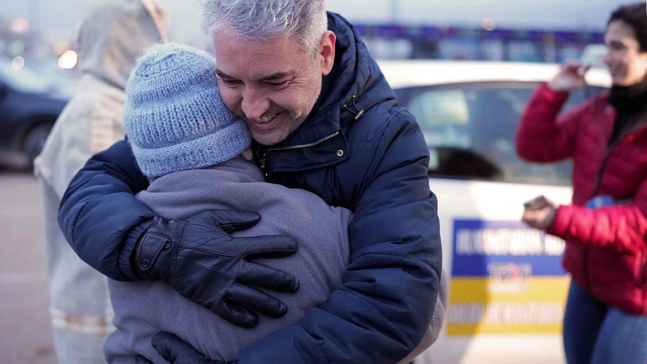 A taxi driver hugs one of the Ukrainian refugees carried by the convoy of Spanish taxi drivers, during a stop in Burgos, on March 16, 2022. Credit: AFP Photo