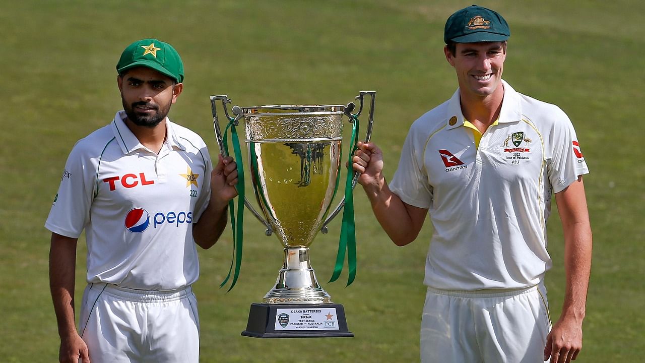 Pakistan's skipper Babar Azam, left, and his Australian counterpart Pat Cummins pose for a photo with the test series trophy. Credit: AP Photo