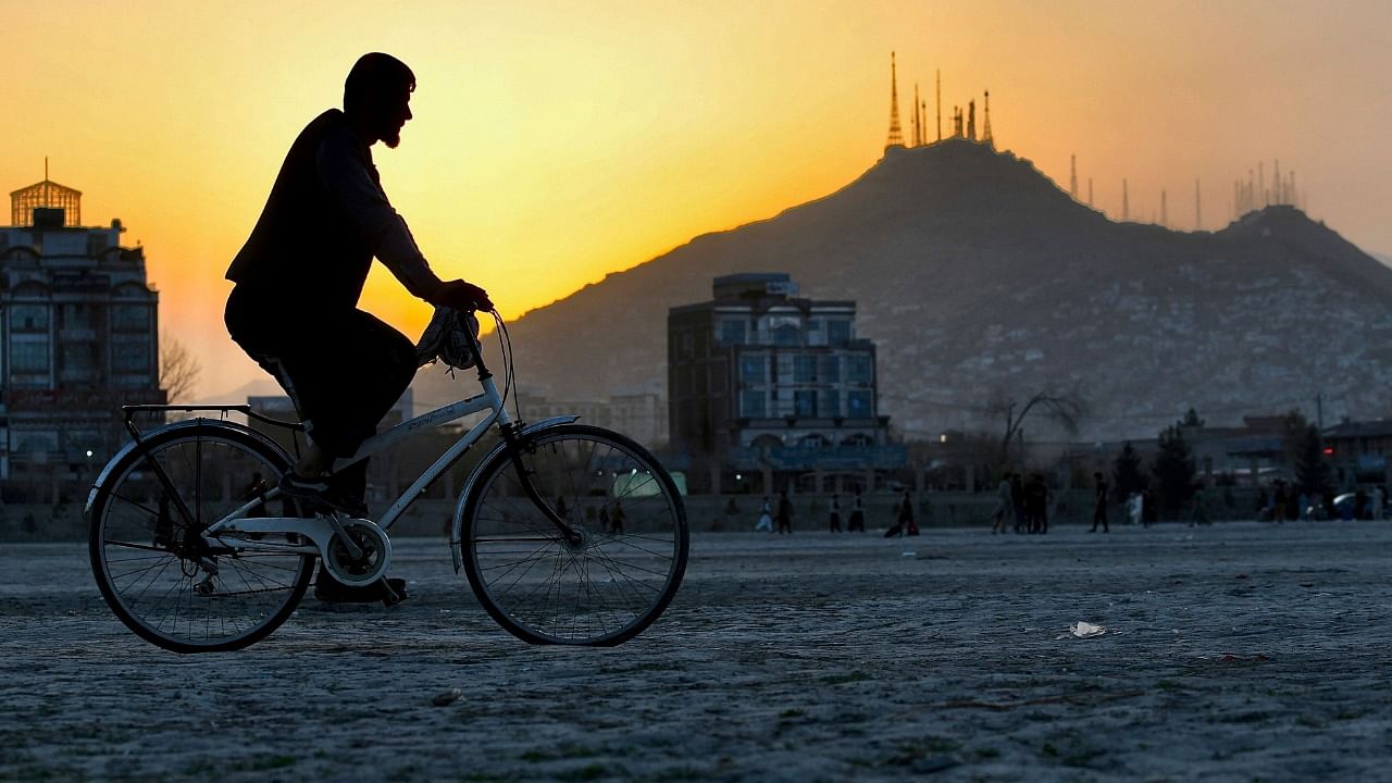 A man rides his bicycle in Chaman-e-Hozori area in Kabul on March 17, 2022. Credit: AFP Photo