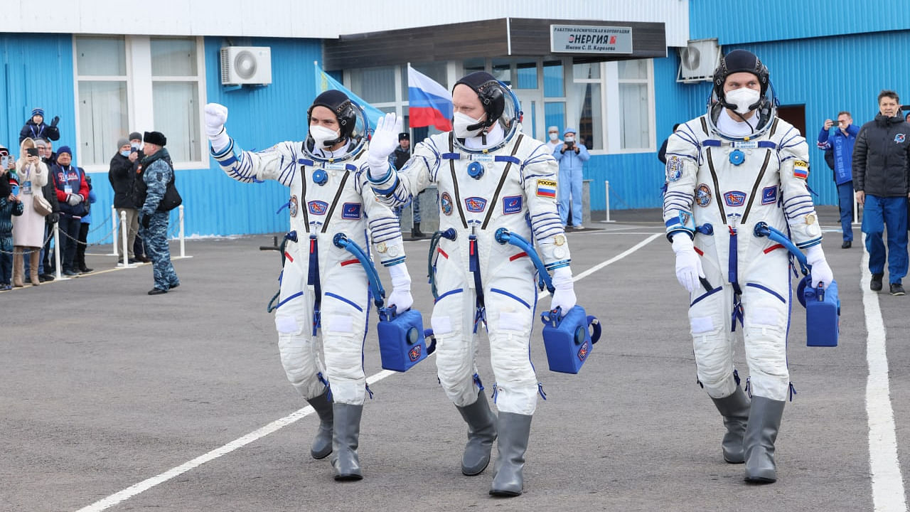 The International Space Station (ISS) crew members Russian cosmonauts Oleg Artemyev, Denis Matveev and Sergey Korsakov walk before departing for boarding the Soyuz MS-21 spacecraft for the launch at the Baikonur Cosmodrome. Credit: Pavel Kassin/Roscosmos/Handout via Reuters