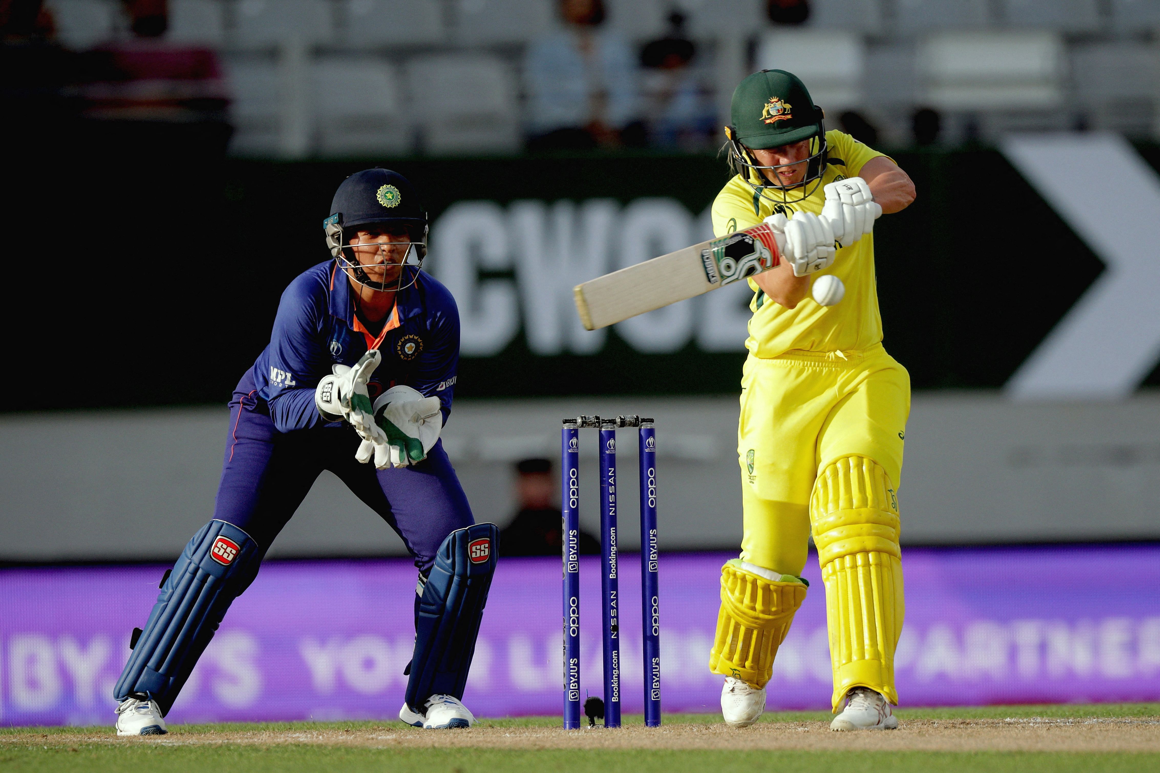 Australia’s Alyssa Healy plays a shot as India’s wicketkeeper Richa Ghosh (L) looks on during the 2022 Women's Cricket World Cup match between Australia and India at Eden Park in Auckland. Credit: AFP Photo