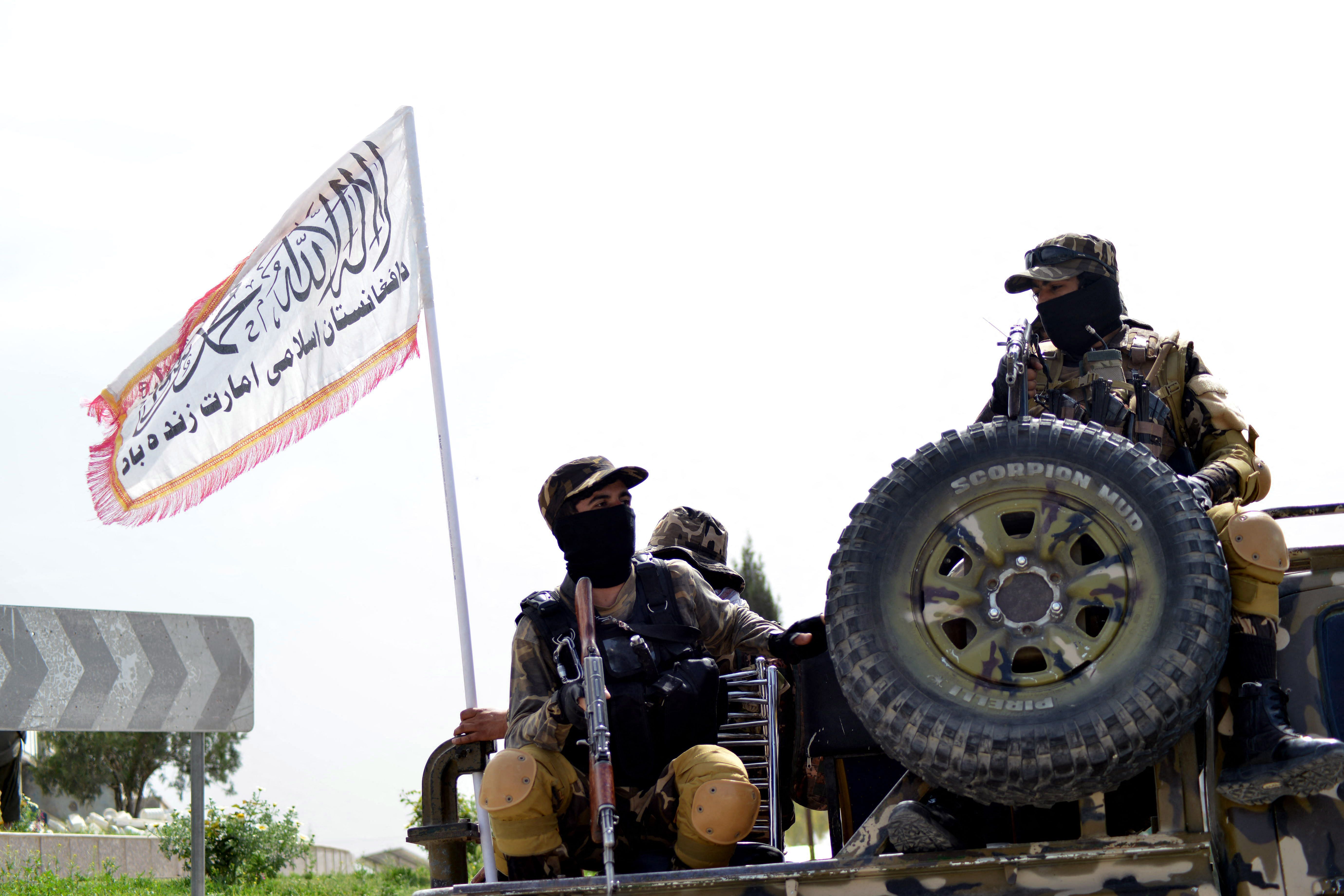 Taliban fighters patrol on the back of a vehicle along a road in Kandahar. Credit: AFP Photo