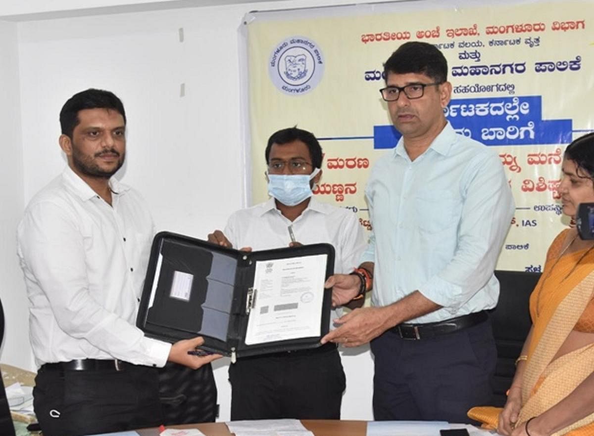 Superintendent of Posts Sriharsha and Mayor Premananda Shetty, sign an MoU towards the doorstep delivery of birth and death certificates, issued by Mangaluru City Corporation, during a programme held at the MCC office on Monday.