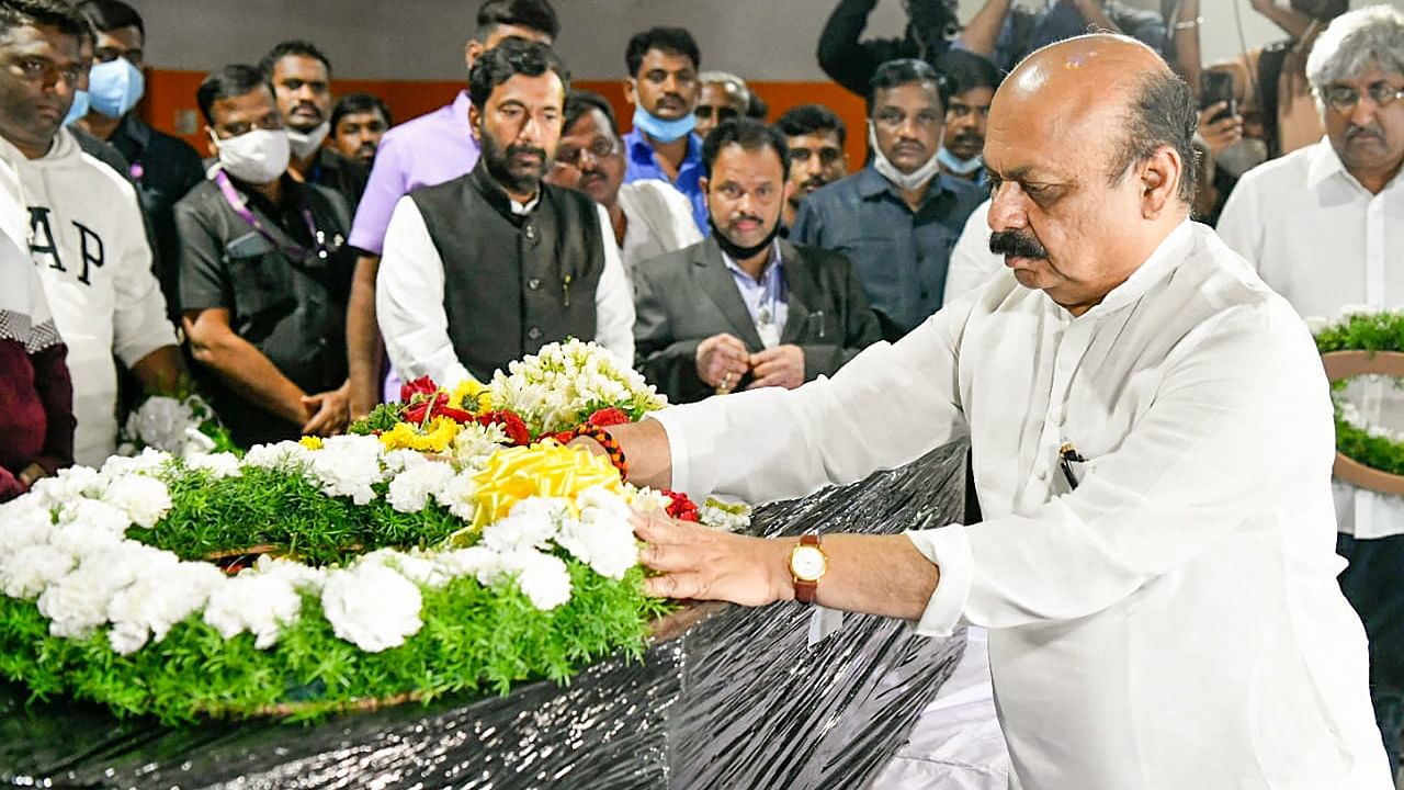 Bommai places a wreath on the mortal remains of Naveen. Credit: PTI Photo