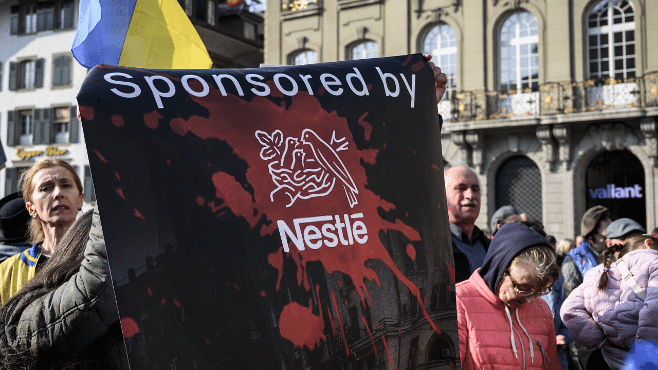 Protesters hold a banner against Swiss food giant Nestle during a demonstration against the Russian invasion of Ukraine next to the Swiss House of Parliament in Bern. Credit: AFP Photo
