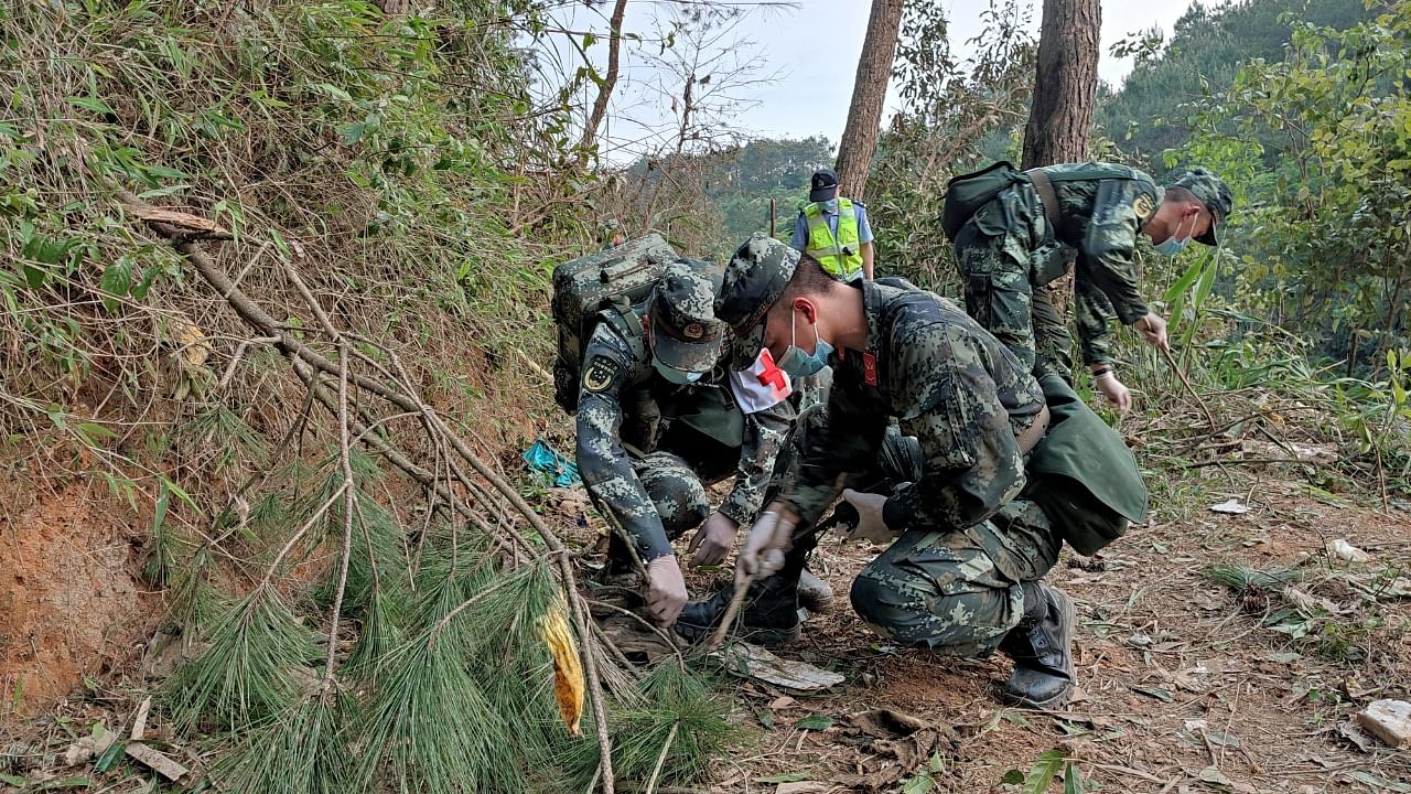 Paramilitary police officers work at the site where a China Eastern Airlines Boeing 737-800 plane flying from Kunming to Guangzhou crashed. Credit: Reuters Photo