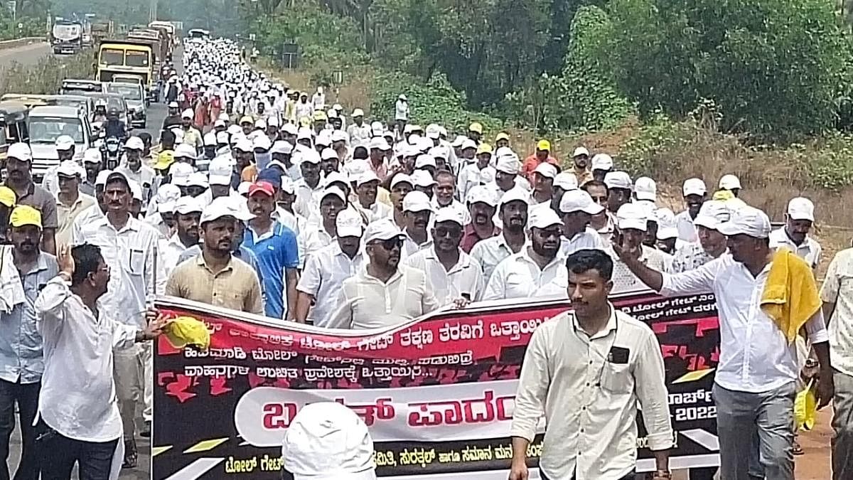 Members of various organisations under the aegis of Toll Gate Virodhi Horata Samiti take part in a foot march in protest against the Surathkal toll plaza from Hejamady on Tuesday. DH photo