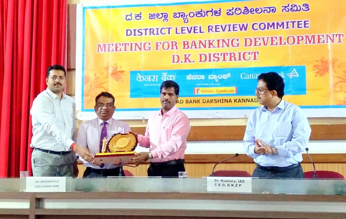 The District Lead Bank was awarded third prize at the state level for the best implementation of PMEGP in the state, during the DLRC meeting at Nethravathi Hall in Mangaluru on Tuesday. RBI, Bengaluru, AGM P Bishwas and Canara Bank, Mangaluru Circle Office DGM Srikanth V K look on. DH Photo