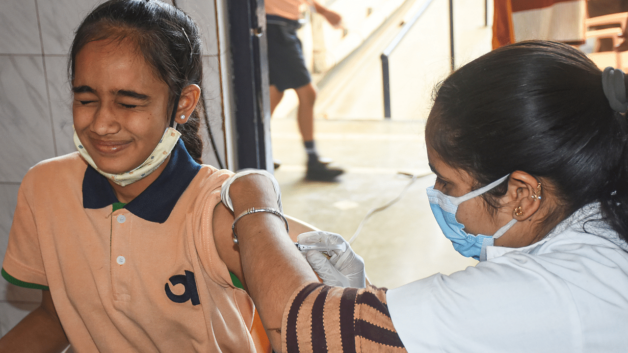 A health worker administers a dose of Covid-19 vaccine to a student in Surat. Credit: PTI Photo