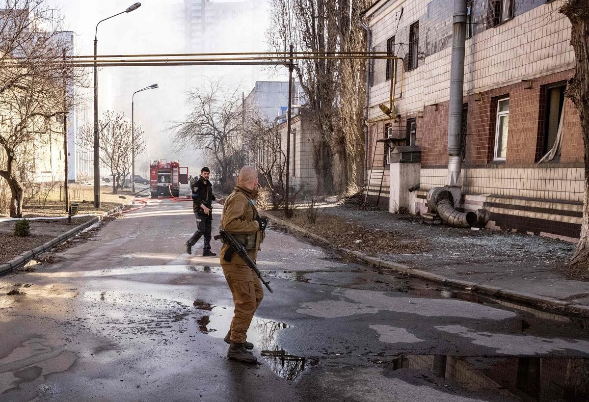 A Ukrainian serviceman walks in the area of a research institute, part of Ukraine's National Academy of Science, after a strike by drones that killed at least one, in northwestern Kyiv, on March 22, 2022. - Russians reinforce their positions around the ca