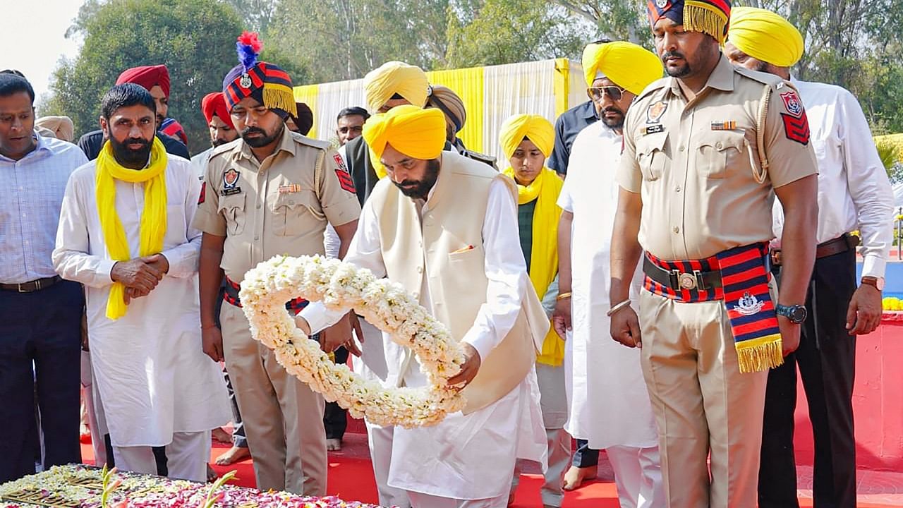 Punjab Chief Minister Bhagwant Mann pays a floral tribute to freedom fighters Bhagat Singh, Rajguru and Sukhdev on the occasion of their 91st death anniversary at Hussainiwala, in Ferozepur. Credit: PTI Photo