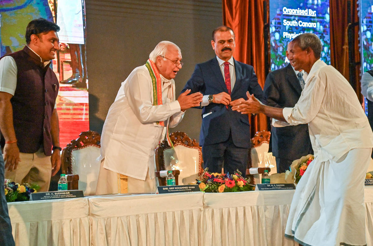 Padma Shri awardee Harekala Hajabba wishes Kerala Governor Arif Mohammad Khan during the inauguration of Mangalore Physiocon 2022 in Mangaluru on Friday. Hajabba was felicitated on the occasion. DH Photo