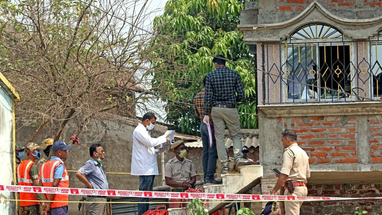 Forensic experts collect samples from the house of Sona Sheikh where seven people were burnt to death. Credit: PTI Photo