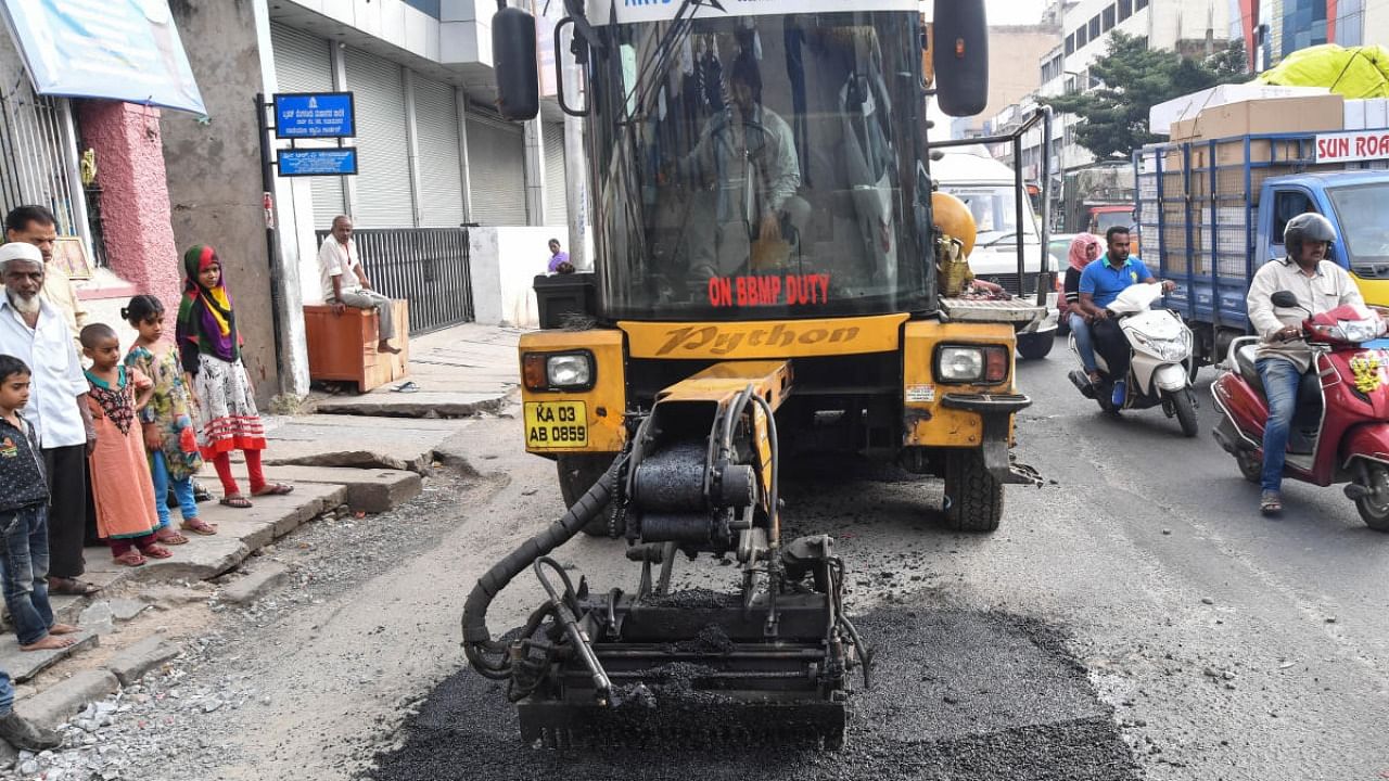 Python, a pothole-filling machine, fills potholes on a stretch in the city. Credit: DH File Photo