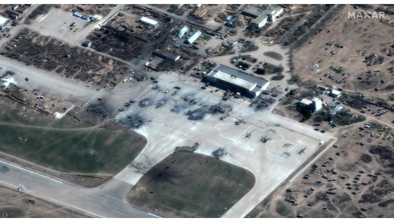 This Maxar satellite image taken and released on March 16, 2022 shows destroyed Russian helicopters on the tarmac at Kherson Airfield. Credit: AFP Photo/Maxar Technologies