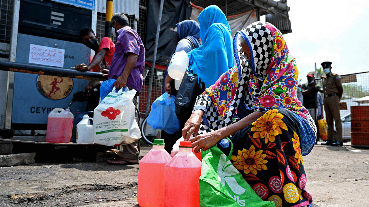  A woman buys kerosene oil for home use at a petrol station in Colombo. Credit: AFP Photo