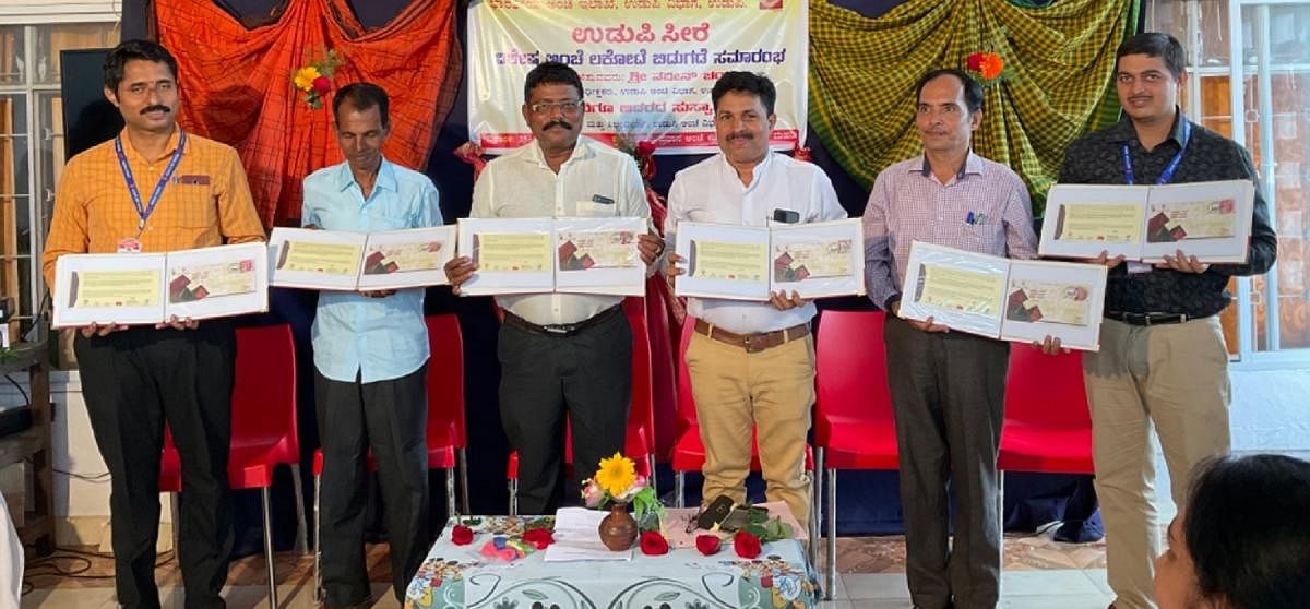 Udupi Postal Superintendent Naveen Chandar and others release a special postal cover on Udupi saree.