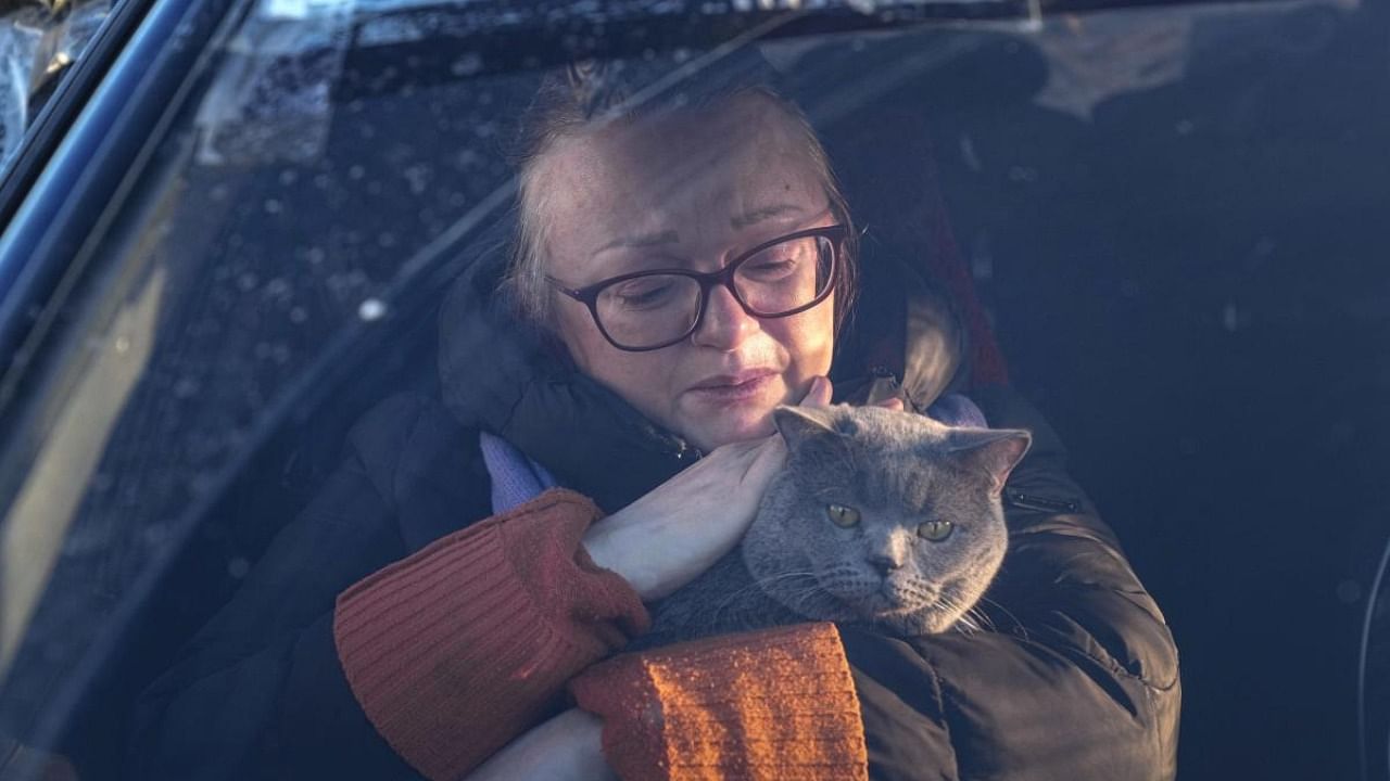 An internally displaced person from Mariupol strokes her cat in a car in Zaporizhia, Ukraine. Credit: AP/PTI Photo