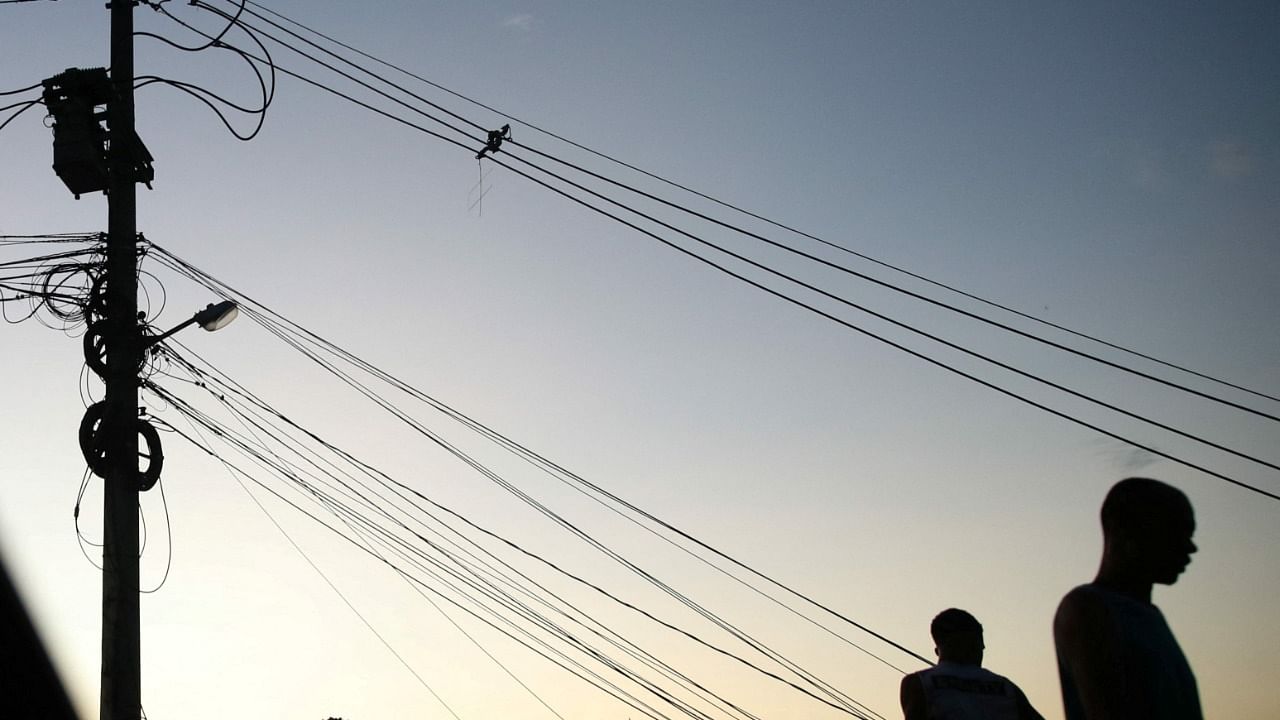 People stand near cables in a suburb of Rio de Janeiro, Brazil. Credit: Reuters File Photo