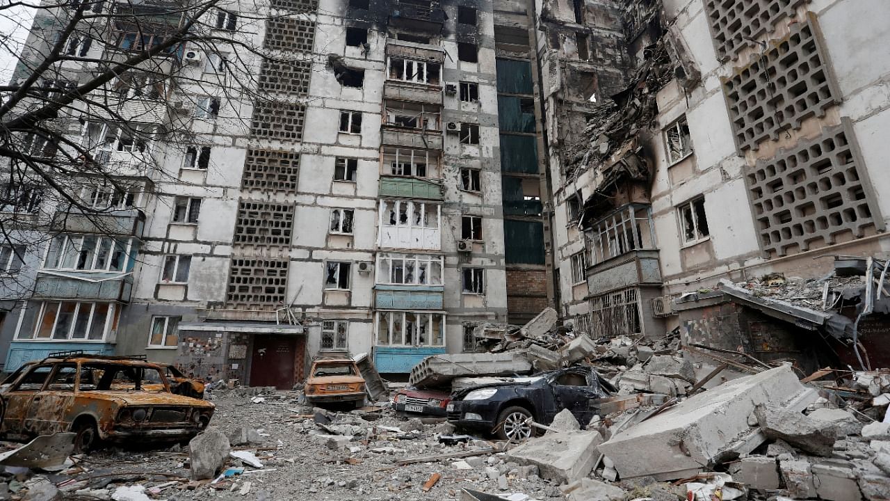 Destroyed cars are seen in front of an apartment building which was heavily damaged during Ukraine-Russia conflict in Mariupol. Credit: Reuters Photo