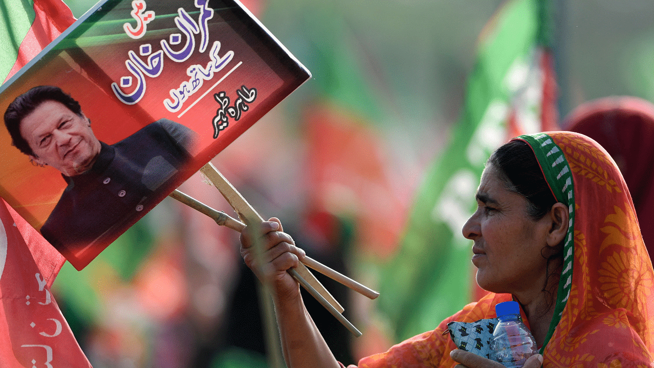 A supporter of ruling Pakistan Tehreek-e-Insaf (PTI) party holds a placard with a picture of Pakistan's Prime Minister Imran Khan during a rally. Credit: AFP Photo