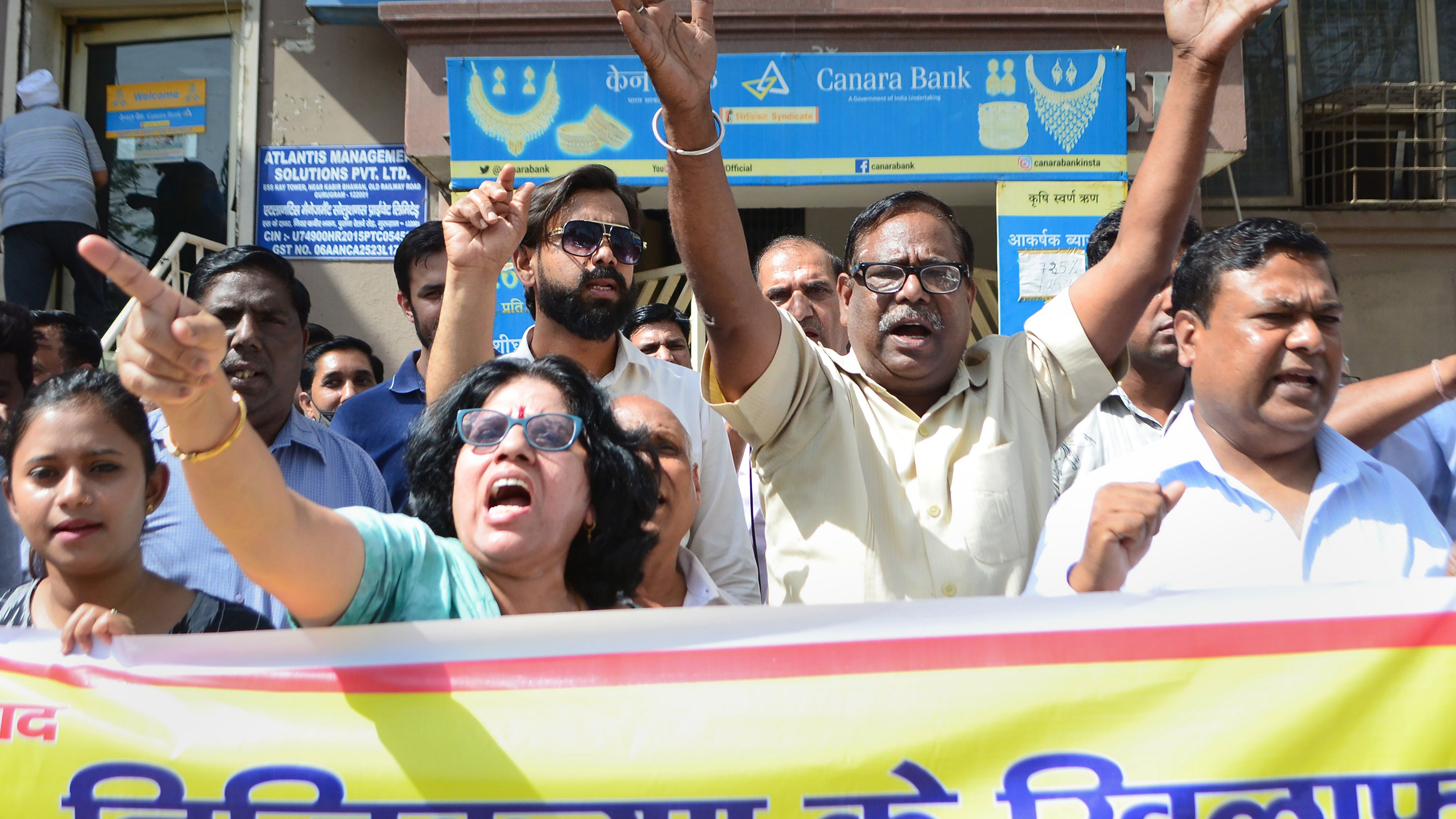 Employees of the Canara Bank raise slogans in protest during 'Bharat Bandh', a two-day nationwide strike supported by the All India Bank Employees Association over the government’s plan to privatise public sector banks and the Banking Laws Amendment Bill 2021, in Gurugram. Credit: PTI File Photo