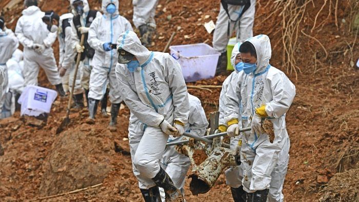 Construction excavators dug into the crash site Saturday in the search for wreckage, remains and the second black box from a China Eastern 737-800 that nosedived into a mountainside in southern China this week with 132 people on board. Credit: AP/PTI Photo