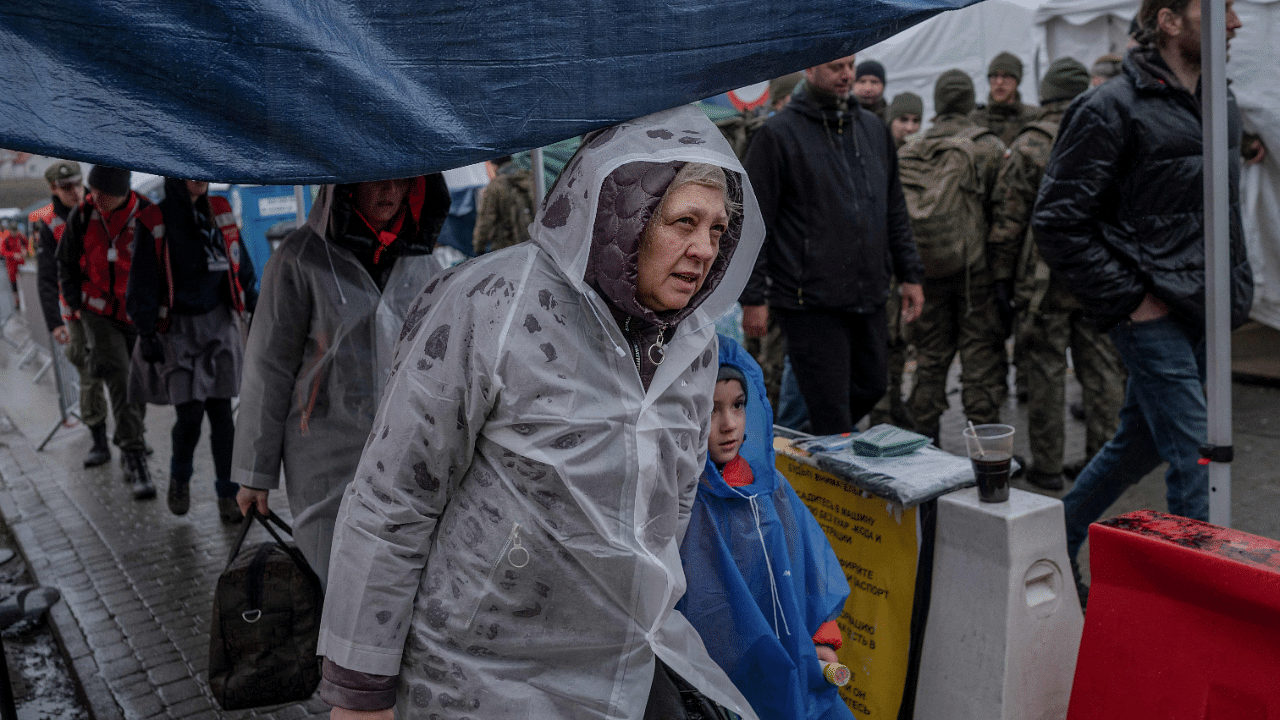 Ukrainian refugees wait to board a bus after crossing the Ukrainian border with Poland at the Medyka border crossing. Credit: AFP Photo