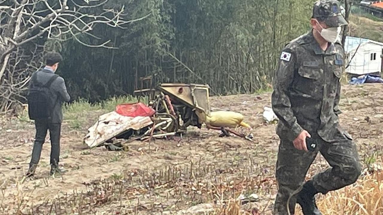 Military personnel are seen near a crashed South Korean air force KT-1 trainer jet (C) near the city of Sacheon, about 300 kilometres south of the capital Seoul on April 1, 2022, after it collided with another KT-1 during training in mid-air, killing four pilots, Seoul's military said. Credit: AFP Photo
