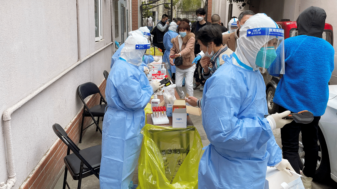 Medical workers in protective suits administer nucleic acid testing for residents in a residential compound, as the second stage of a two-stage lockdown to curb the spread of the coronavirus. Credit: Reuters Photo