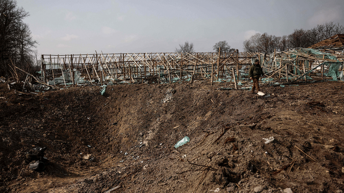 Ukrainian soldiers patrol near a crater made by the explosion of two missiles on the outskirts of Kyiv. Credit: AFP Photo