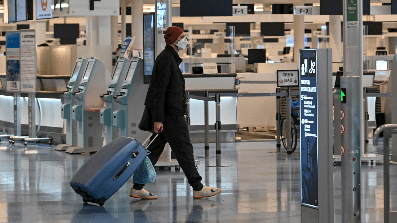 A man walks past check-in counters at an international flight departure floor at Tokyo's Haneda airport. Credit: AFP Photo