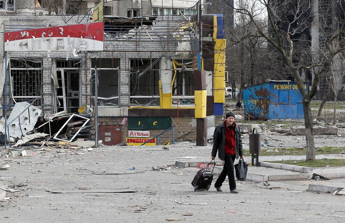 A man walks near a building damaged in the course of Ukraine-Russia conflict in the southern port city of Mariupol. Credit: Reuters Photo