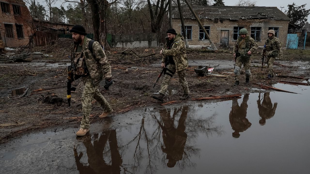 Ukrainian service members walk on the street, amid Russia's invasion of Ukraine, near the village of Kozarovychi, in Kyiv. Credit: Reuters Photo