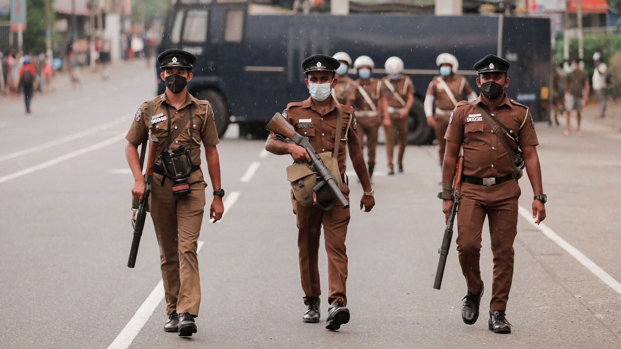 Sri Lankan police officers with tear gas guns walk along a main road as people protest against President Gotabaya Rajapaksa in Colombo. Credit: Reuters Photo