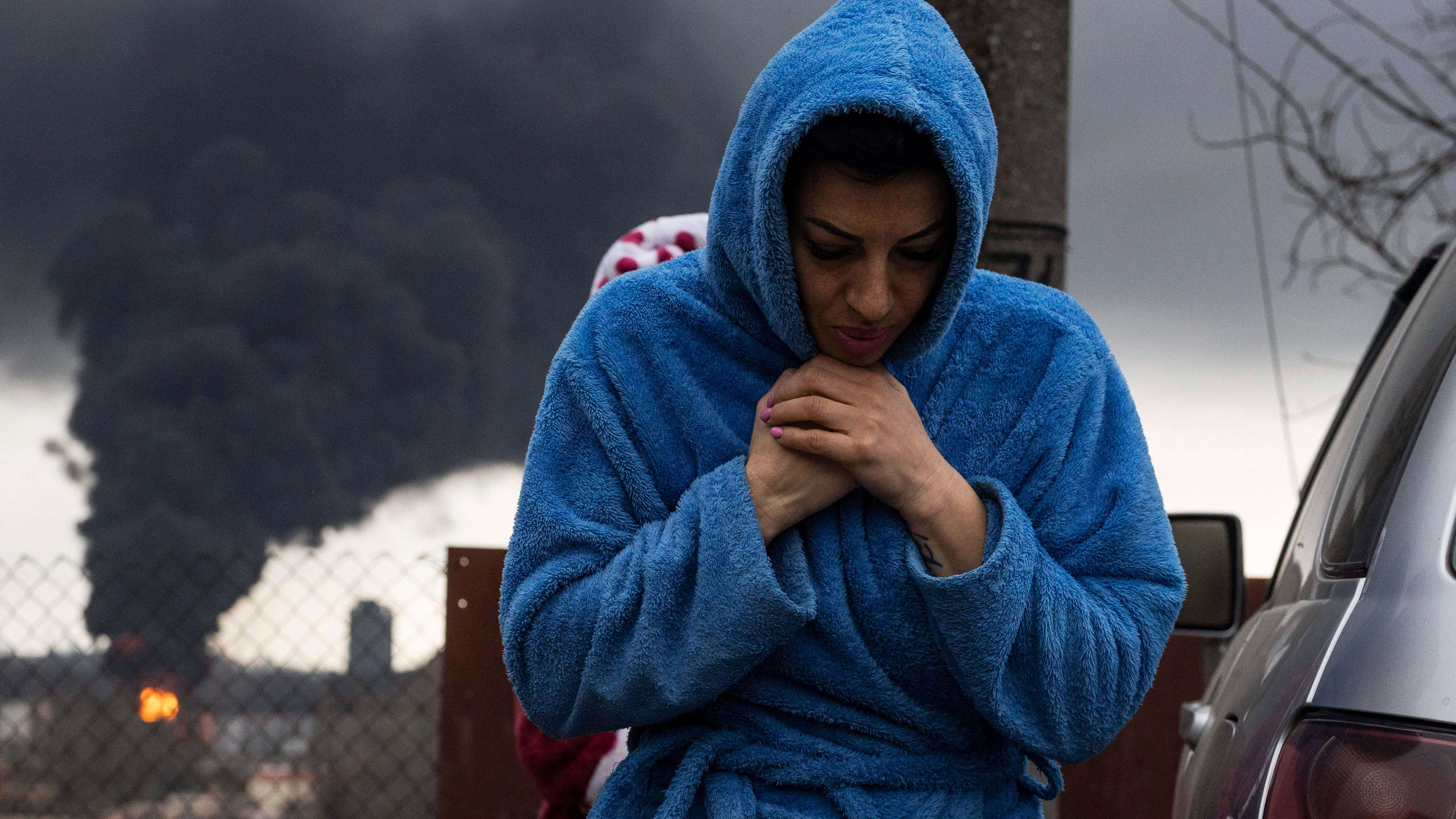 A woman walks as smoke rises in the air in the background after shelling in Odessa, Ukraine. Credit: AP Photo