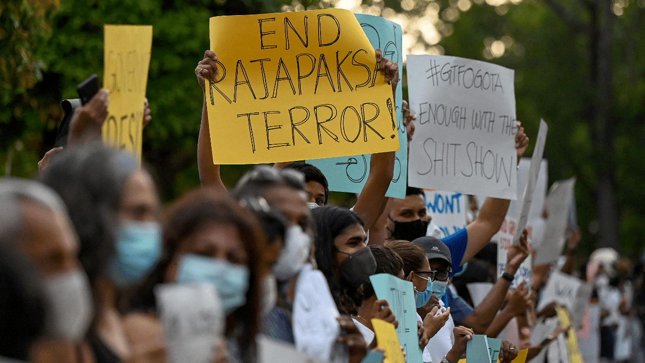 Protestors hold banners and placards during a demonstration against the surge in prices and shortage of fuel and other essential commodities in Colombo. Credit: AFP Photo