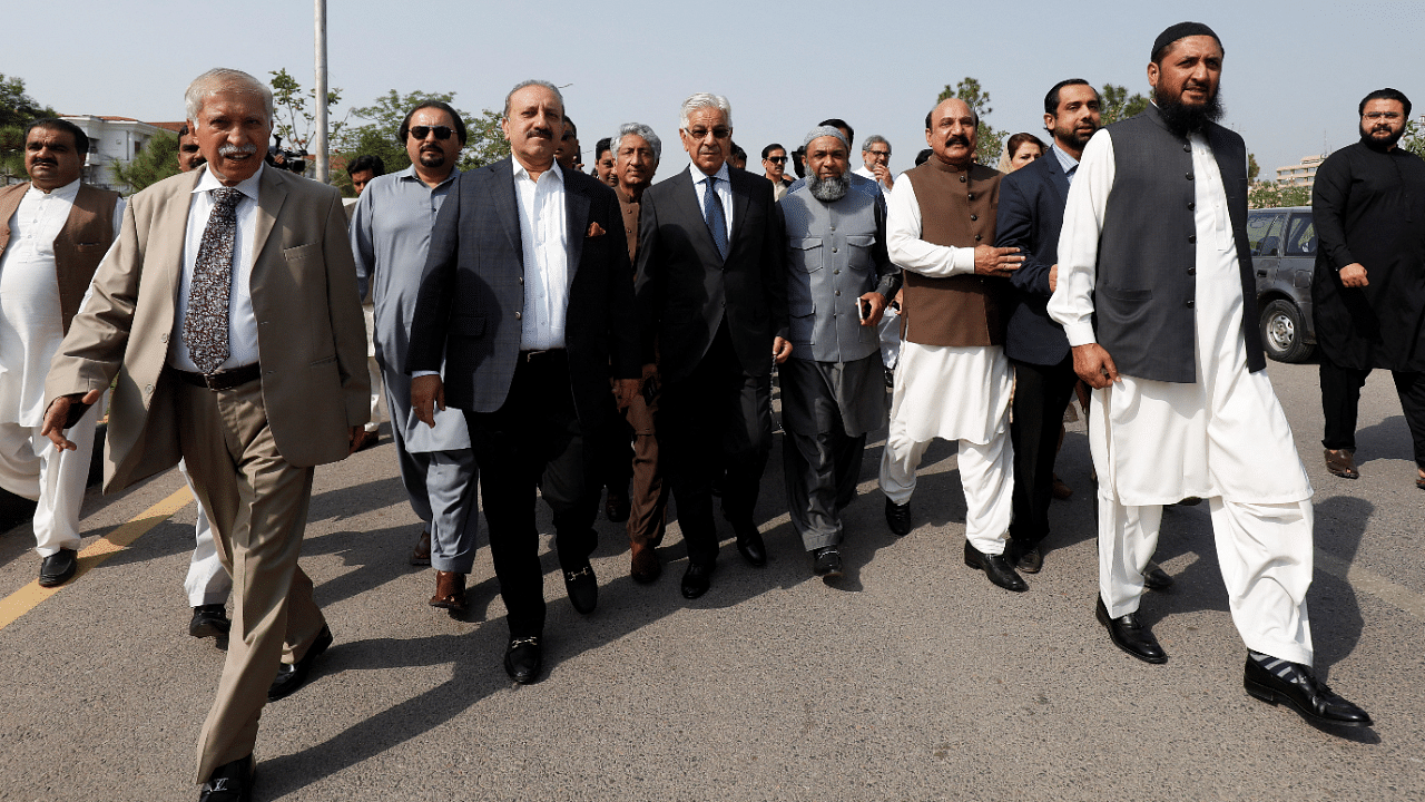 Pakistani lawmakers of the united opposition walk towards the parliament house building to cast their vote on a motion of no-confidence to oust PM Imran Khan, in Islamabad. Credit: Reuters Photo