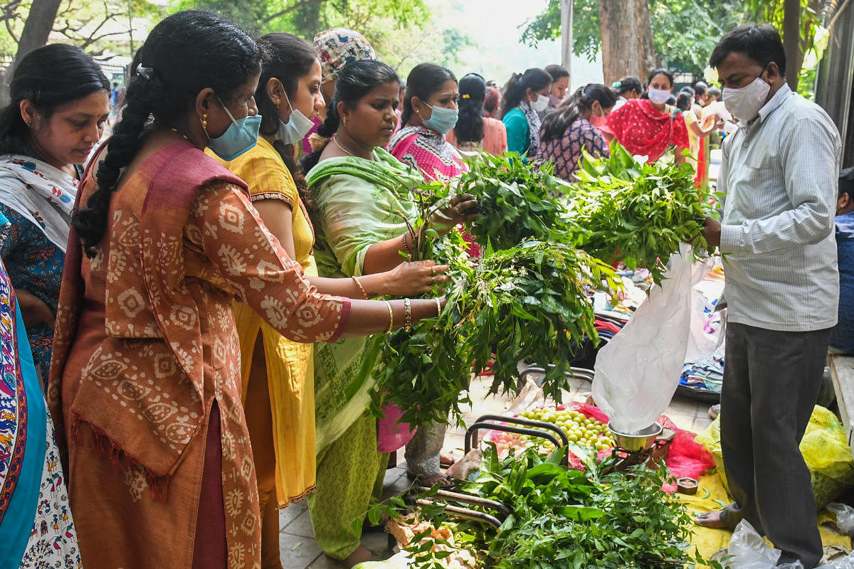 Women purchase neem on the eve of Ugadi at MS Building, Dr B R Ambedkar Veedhi, on Friday. DH PHOTO/S K Dinesh