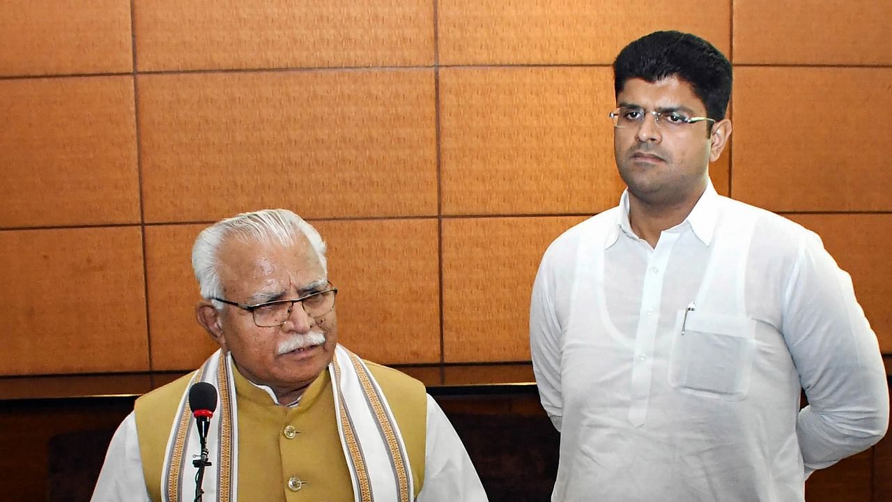 Haryana Chief Minister Manohar Lal Khattar addresses a press conference as Deputy CM Dushyant Chautala looks on, in Gurugram. Credit: PTI Photo