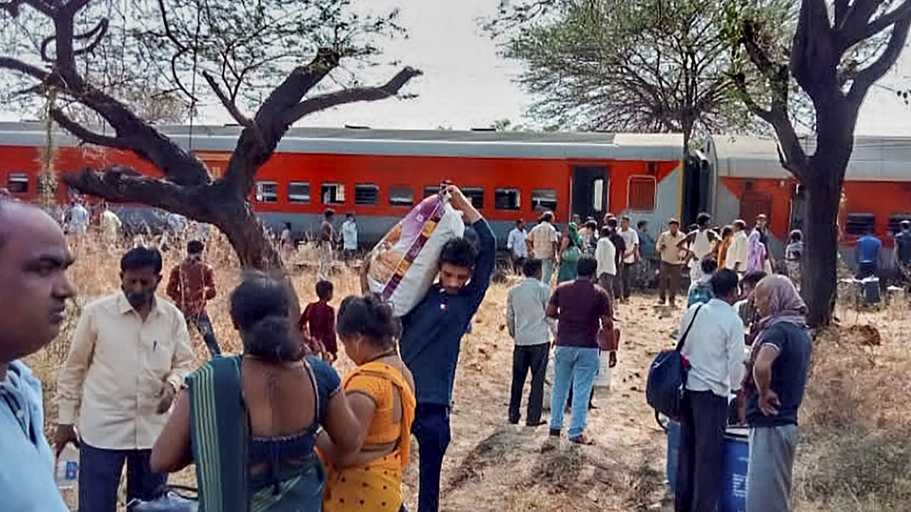 Passengers wait near the Pawan Express train after several coaches of the train derailed between Lahavit and Devlali railway stations, near Nashik. Credit: PTI Photo