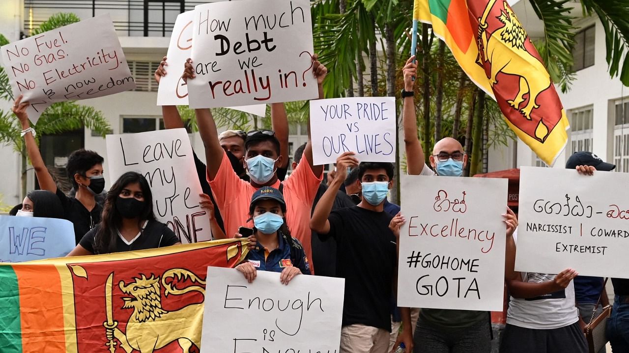 Protestors hold banners and placards during a demonstration against the surge in prices and shortage of fuel and other essential commodities in Colombo. Credit: AFP Photo