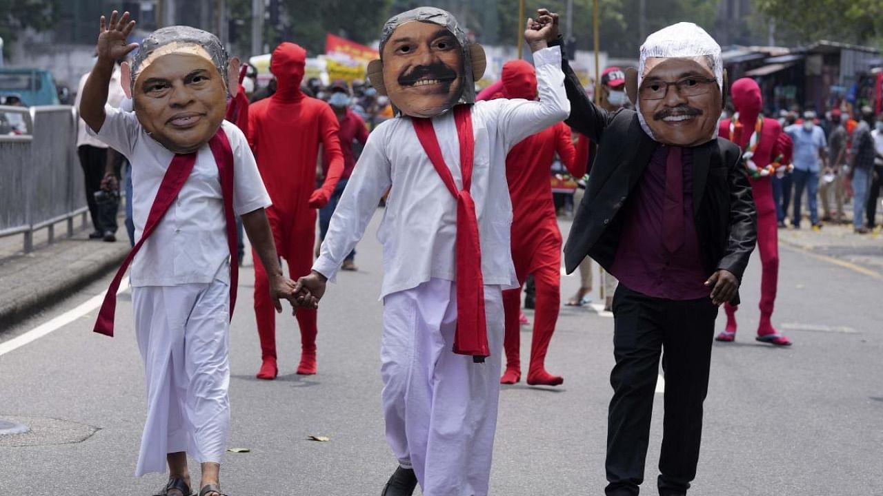 Members of the Socialist Youth Union dressed as Sri Lankan president Gotabaya Rajapaksa, right, and his brothers, finance minister Basil, left, and prime minister Mahinda walk during a protest against the worst economic crisis in memory in Colombo, Sri Lanka, Friday, March 18, 2022. Credit: AP Photo