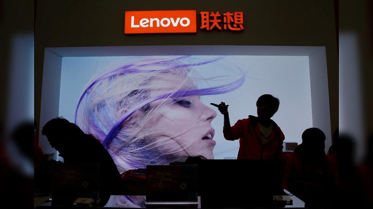 An employee gestures next to a Lenovo logo at Lenovo Tech World in Beijing. Credit: REUTERS FILE PHOTO