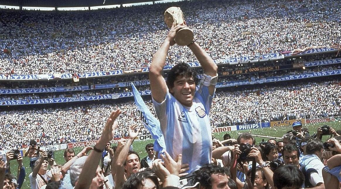 Diego Maradona holds up his team's trophy after Argentina's 3-2 victory over West Germany at the World Cup final soccer match at Atzeca Stadium in Mexico City. Credit: AP FILE PHOTO