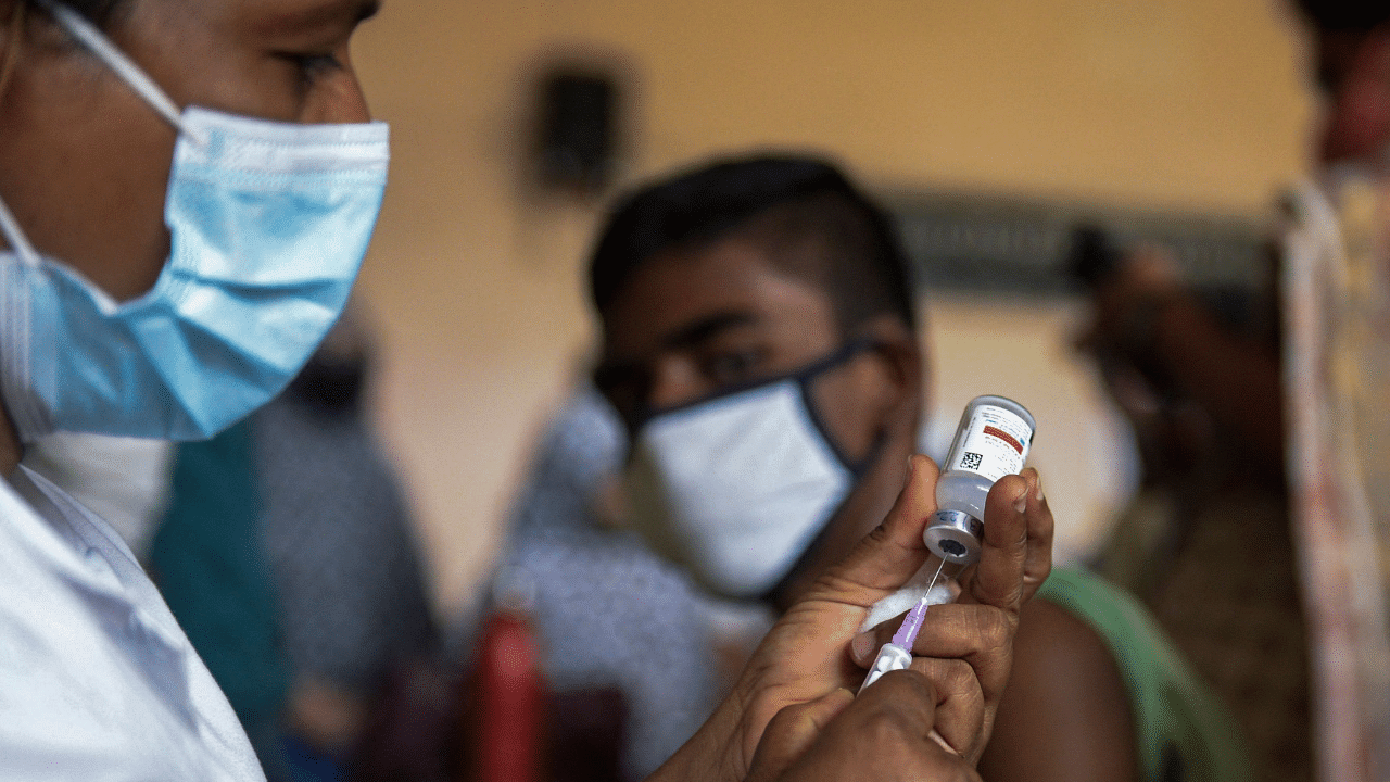 A health worker prepares to inoculate a child with a dose of the Covid-19. Credit: AFP Photo